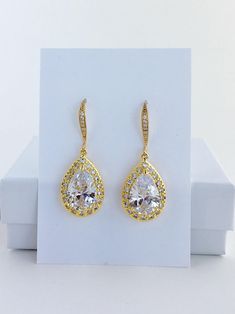 Luxury clear cubic zirconia bridal tear drop dangle earrings in gold plated brass setting. Earrings feature a large teardrop with pear cut clear cubic zirconia center surrounded by tiny round zirconia crystals. Teardrop dangles from a ear wire detailed with tiny zirconia crystals. Total length of the earrings is 3.8 cms. For matching necklace click: https://www.etsy.com/listing/505396034/gold-crystal-necklace-gold-cubic?ref=shop_home_active_12 For matching bracelet click: https://www.etsy.com/li Classic Gold Drop Bridal Earrings, Elegant Yellow Gold Teardrop Earrings For Wedding, Gold Teardrop Earrings With Elegant Design For Wedding, Gold Teardrop Earrings For Wedding, Gold Earrings For Bridal Shower, Gold Teardrop Bridal Earrings For Formal Occasions, Gold Teardrop Bridal Earrings For Bridal Shower, Gold Cubic Zirconia Teardrop Earrings As Gift, Classic Gold Teardrop Bridal Earrings