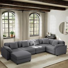 a large sectional couch in front of two windows