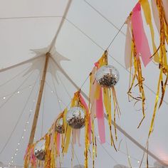 disco balls and streamers are hanging from the ceiling in a marquee tent