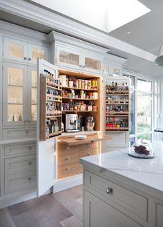 an open cabinet in the middle of a kitchen with lots of counter space and drawers