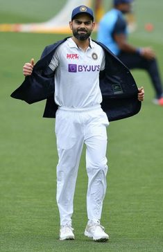 a man holding a jacket on top of a field