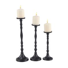 three black candles with white candles in them