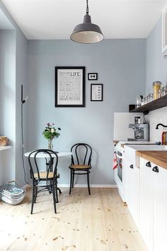 two chairs sitting at a table in a room with blue walls and wood flooring