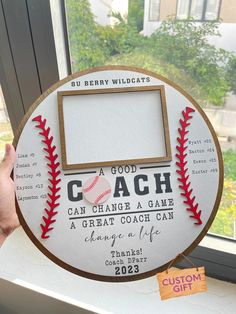 a person holding up a baseball plaque with the words, a good coach can change a game a great coach can change a life