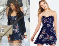 a woman in a blue floral dress is looking at the camera and then she has her hand on her hip