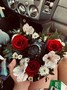 a person holding a bouquet of flowers in their hand while taking a photo with a camera