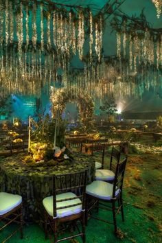 tables and chairs are set up for an outdoor event with chandeliers hanging from the ceiling