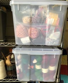 two plastic containers filled with yarn on top of a metal shelving unit in a closet