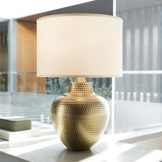 a lamp sitting on top of a table next to a window