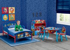 a child's bedroom with blue walls and toys on the floor, including a toy bed