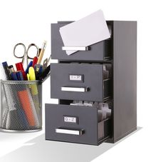 an office file cabinet next to a pen holder with scissors and pencils in it