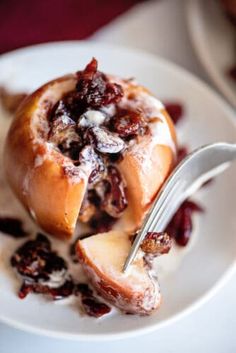 a white plate topped with an apple covered in cranberry sauce