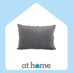 a gray pillow sitting on top of a blue and white background with the at home logo