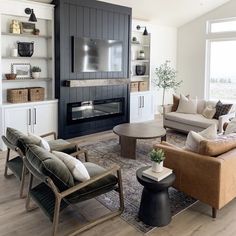 a living room filled with furniture and a flat screen tv mounted on the wall above a fireplace