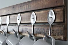 spoons are hanging on the wall with hooks