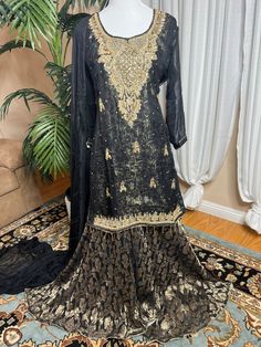 Ready to wear can ship same business day. Color     Black and gold  Fabric    shirt, dupatta (chiffon)                 Inner banarsi jamavar and also a soft                  Layer underneath                  Sharara fabric Banarsi chiffon  Embroidery details  Total handmade adda work Kora, Dabka, Stones, Pearls The fabric used in this dress is very high quality. Embroidery is very elegant and neat and gives designer dress. Very high quality nicely stitched stylish sharara suit. Size Large  Shoulder 17 Chest 22 Waist 21 Hips 23 Shirt length 35 Sharara length 44 This dress is available in size  large  ready to wear and  can ship immediately. if you need same dress in other sizes  can be made to your size contact me 818-687-2408  for your customize size. Thanks Black And Gold Fabric, Chiffon Embroidery, Indian Wedding Dresses, Soft Layer, Dresses Handmade, Sharara Suit, Soft Layers, Gold Fabric, Indian Wedding Dress