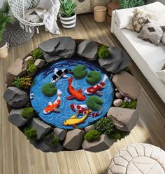 a fish pond surrounded by rocks and plants in the middle of a living room area