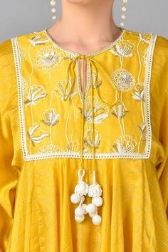 Yellow kurta with floral embroidered motifs and contrast zari stripes. Paired with striped palazzo and inner.
Component: 3
Embroidered
Neckline: Round
Sleeve Length: Three quarter
Fabric: Chanderi Silk, Georgette
Color: Yellow
Front tassel tie-up
 - Aza Fashions Elegant Spring Kurta With Dori Work, Elegant Spring Sets With Gota Work, Designer Spring Dresses With Gota Work, Elegant Sets With Dori Work For Spring, Traditional Gota Work Dress For Spring, Traditional Dresses With Gota Work For Spring, Traditional Spring Dress With Gota Work, Spring Festive Anarkali Set With Dori Work, Kurta And Palazzo