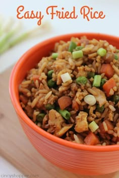 an orange bowl filled with rice and vegetables