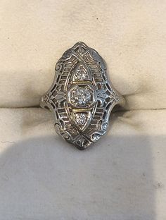 an antique ring is sitting on a white cloth