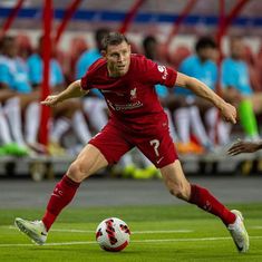 a soccer player in action on the field during a game with other players behind him