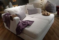 a large white couch sitting on top of a hard wood floor