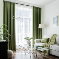 a living room filled with furniture and green curtains