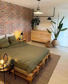 a bedroom with brick wall and wooden bed frame in the middle, surrounded by potted plants