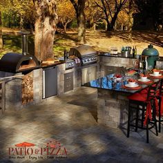 an outdoor kitchen with grill, table and chairs