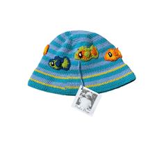 a knitted hat with fish on it and a tag hanging from the front side