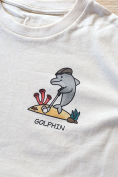 The material of this Golphin t-shirt is 100% organic ring-spun combed cotton. The inks used in the print are water-based and non-toxic. We ship this product in top quality eco-friendly recyclable cardboard pouches. Available in White, Natural and Navy. Sizes XS - XXL. Silly Shirt, Mia 3, Weird Shirts, Cute Fits, Dream Clothes, 그림 그리기, Look Cool, Funny Shirts, Aesthetic Clothes