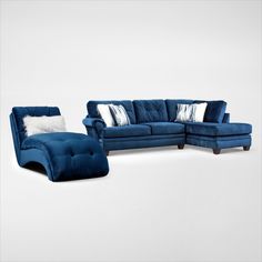 a blue couch and chair sitting next to each other on a white floor with pillows