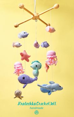 a group of stuffed animals hanging from strings on a yellow background with the caption kaalakala crochet doll handmade