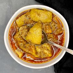 a white bowl filled with meat and sauce