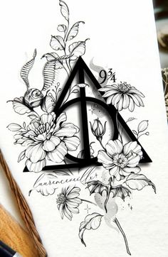 the letter d is surrounded by flowers and leaves on a piece of paper with pencils next to it