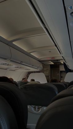 the inside of an airplane with people sitting in seats