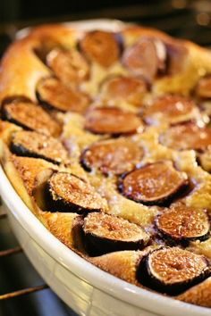 a baked dish in an oven with figs on the top and bottom, ready to be eaten