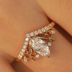 a woman's hand with a gold ring on it and a diamond in the middle