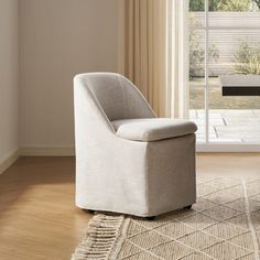 a white chair sitting on top of a wooden floor next to a sliding glass door