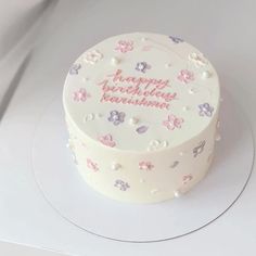 a white cake with pink and purple flowers on it