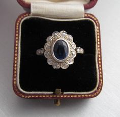 Antique diamond and kyanite cluster engagement ring, made of 14K gold and silver combination. It has a 14K gold hallmark that was used between 1867 and 1937. It was made in Austria. Total diamond weight: 0.35 carat Size of the kyanite stone: 0.291 x 0.224 inches (7.4 x 5.7 mm) Size of the head part: 0.563 x 0.469 inches (14.3 x 11.9 mm) Inside diameter: 0.6972 inches (17.71 mm) Size 7½ US Weight: 3.4 gram The box is not part of the auction. Free world-wide shipping by FedEx. Antique Cluster Ring As A Gift, Vintage Sapphire Cluster Ring With Gemstones, Antique Sapphire Ring With 17 Jewels, Antique Oval Cluster Ring As Gift, Vintage Sapphire Ring As A Gift, Antique Oval Cluster Ring For Gift, Antique Gemstone Cluster Ring For Anniversary, Vintage Sapphire Ring For Gift, Antique White Gold Sapphire Ring With 17 Jewels