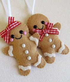 three gingerbread christmas ornaments hanging from strings