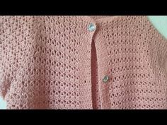 a pink crocheted cardigan with buttons on it