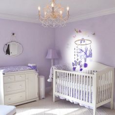 a baby's room with purple walls and white furniture