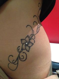 a woman's stomach with a tattoo design on the lower part of her belly