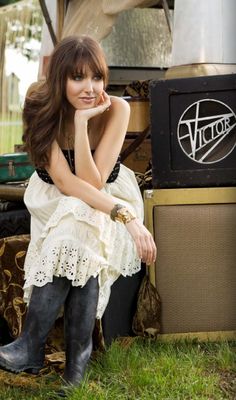 a woman sitting on the ground next to an amp