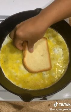 a person is frying some food in a skillet on the stove with a slice of bread