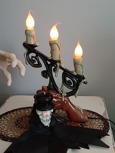 2 Halloween props to choose from.  Flickering 3 bulb candelabra with a spooky hand. Electric and in excellent working order. Minor paint loss, please refer to the photos for more information. Made of hard plastic. How can something so spooky be so cute. 14 inches tall. Let's just talk about cute... This phantom/skull hanger is battery operated with glowing red eyes. 11 inches tall. In excellent working condition with minor paint loss on his hat. Please refer to the photos for more information. M Glowing Red Eyes, Flickering Lights, Halloween Vintage, Vintage Chandelier, Halloween Props, Retro Halloween, Red Eyes, Antique Shops, Vintage Halloween