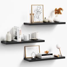 two black shelves with books and vases on them