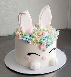 a white cake decorated with flowers and bunny ears